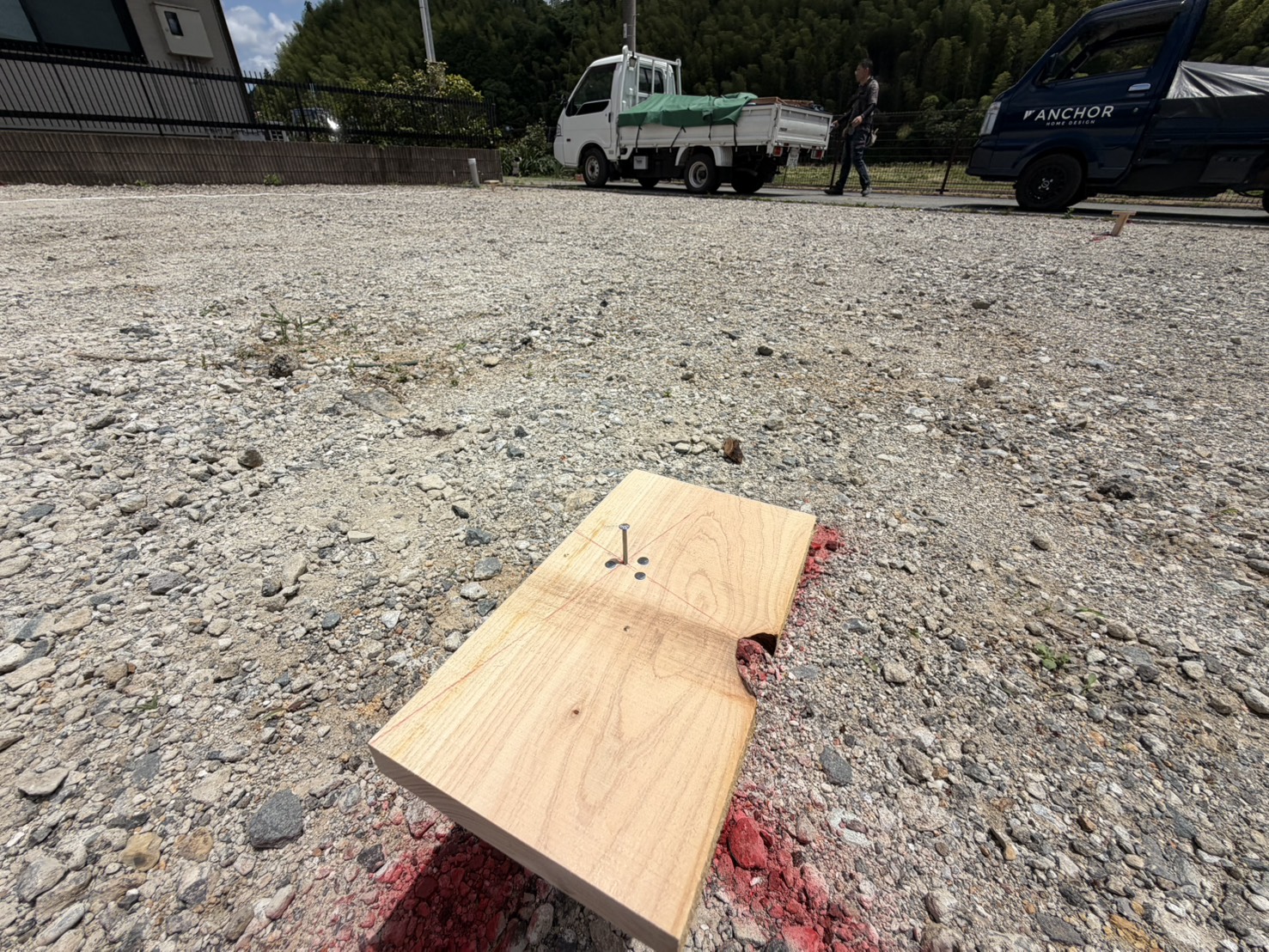 丁張りの基準点として地面に打ち込まれた木の板と釘の接写写真