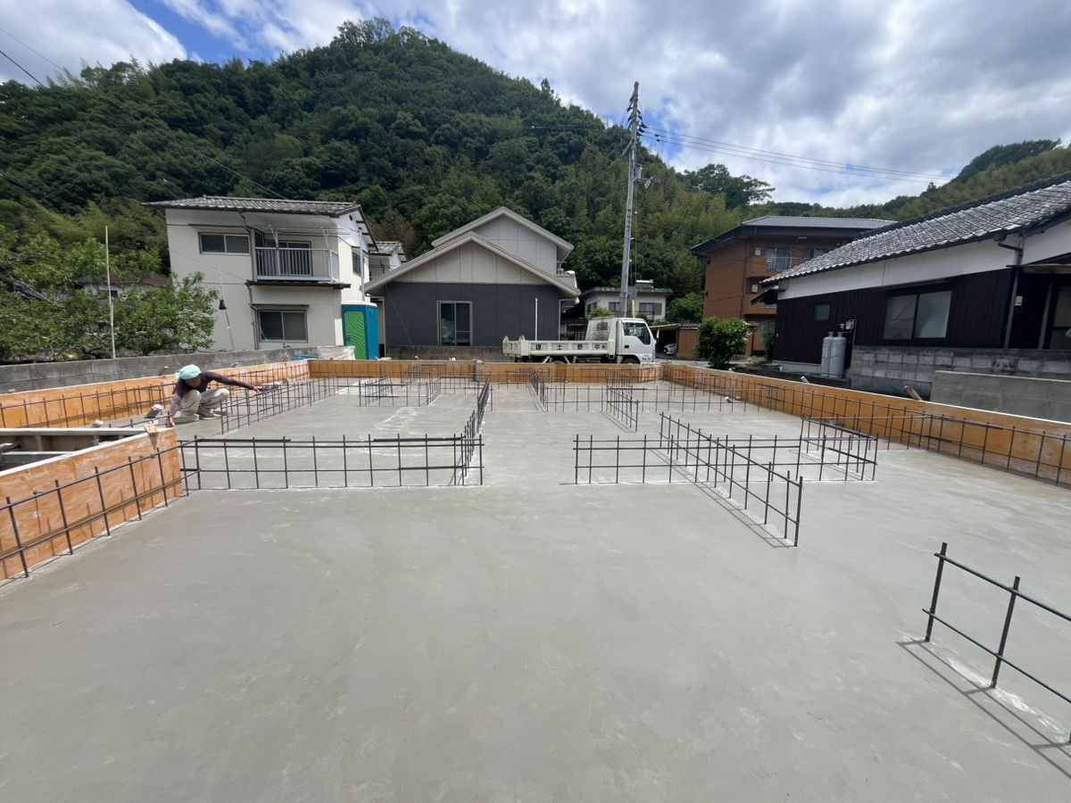 打設作業が進み、基礎全体に均一にコンクリートが充填された宇和島市RO様邸の基礎工事現場の全景