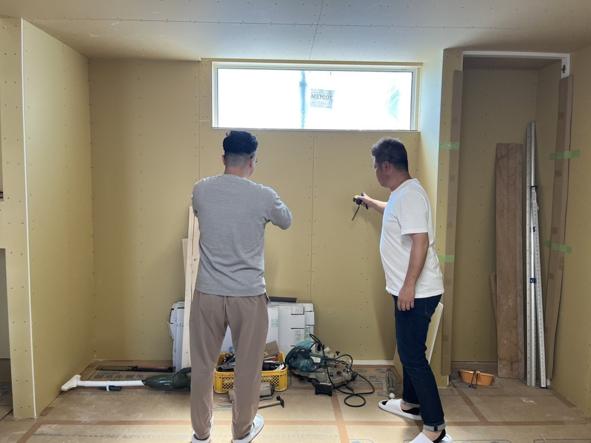 YN様とスタッフが内部空間の施工状況を指差ししながら確認している様子