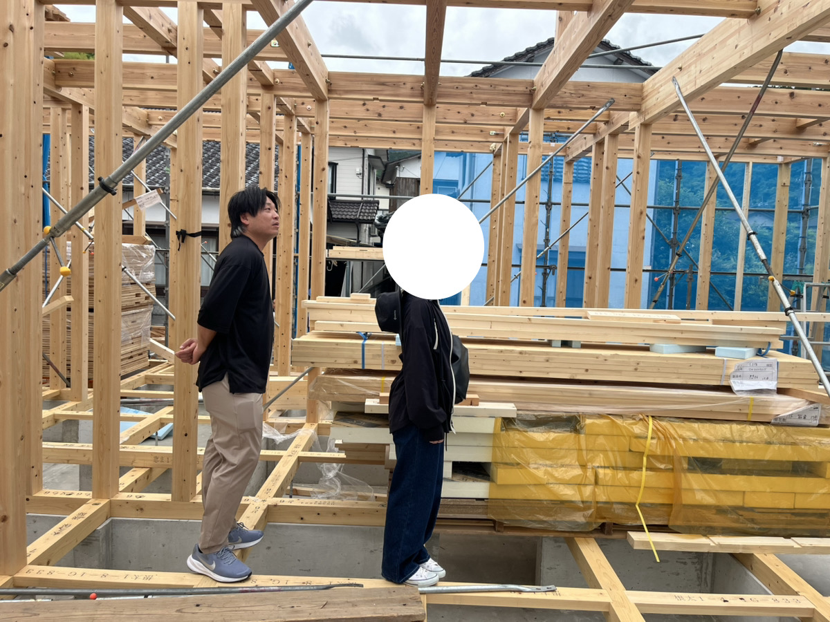 組み上がった柱や梁の構造を、建物内に入って確認するO様ご夫婦