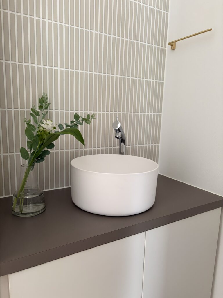 トイレの手洗いスペースに季節の花を飾り、空間を華やかに演出した完成見学会のコーディネート